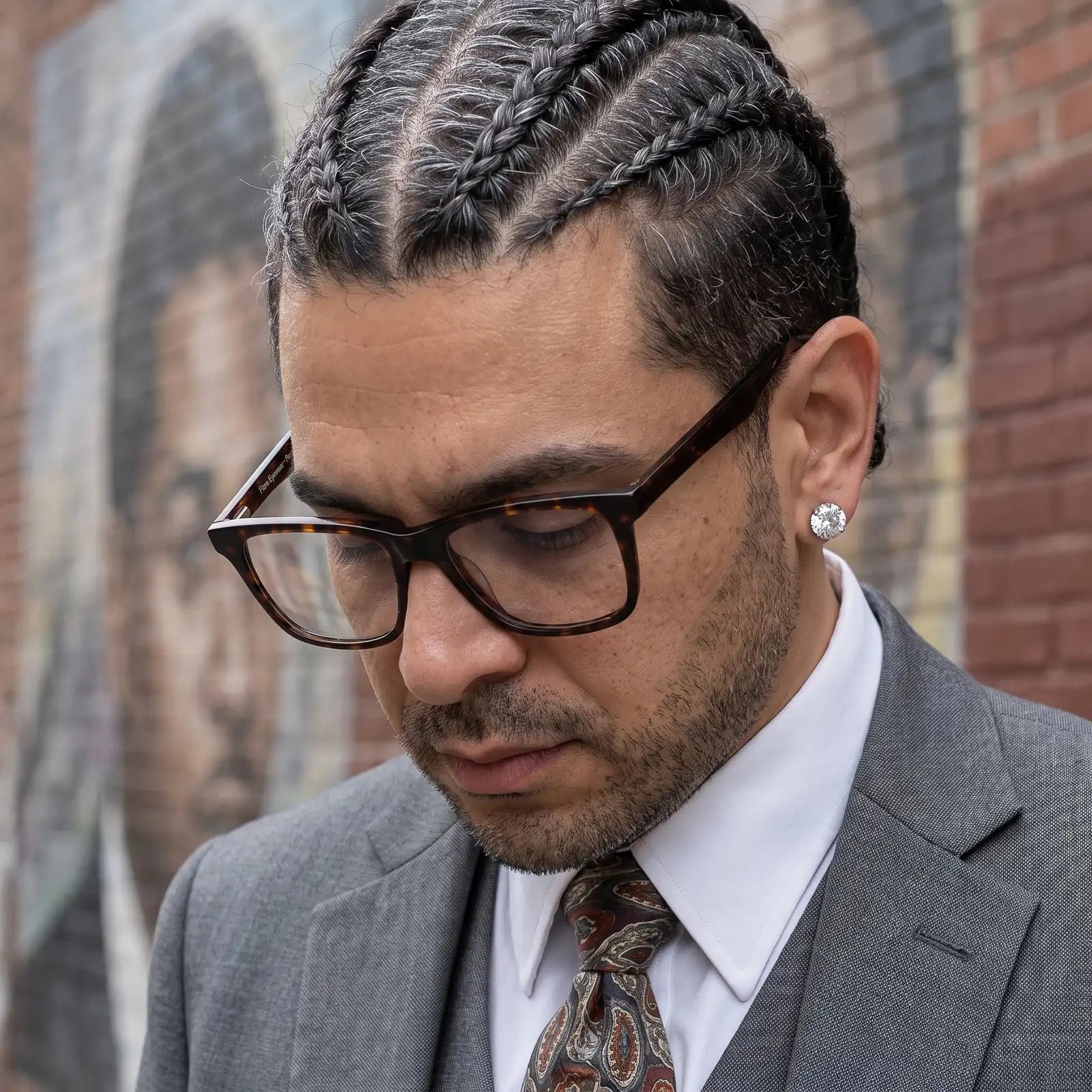 Fiore 5228 eyeglasses in tortoiseshell, worn by a model – campaign portrait, pensive portrait against a painted brick mural