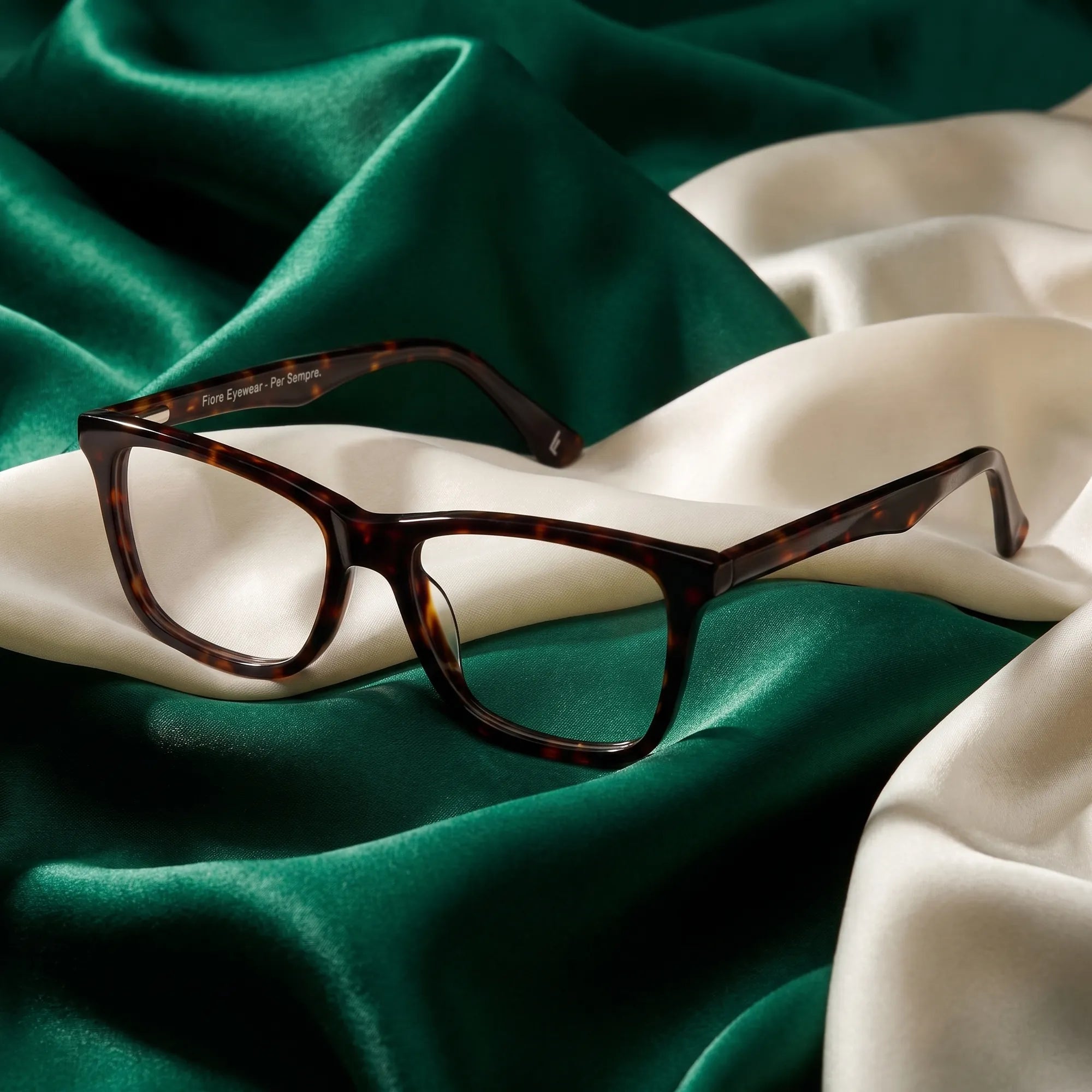 Fiore 5228 eyeglasses in tortoiseshell – resting on draped emerald and ivory silk
