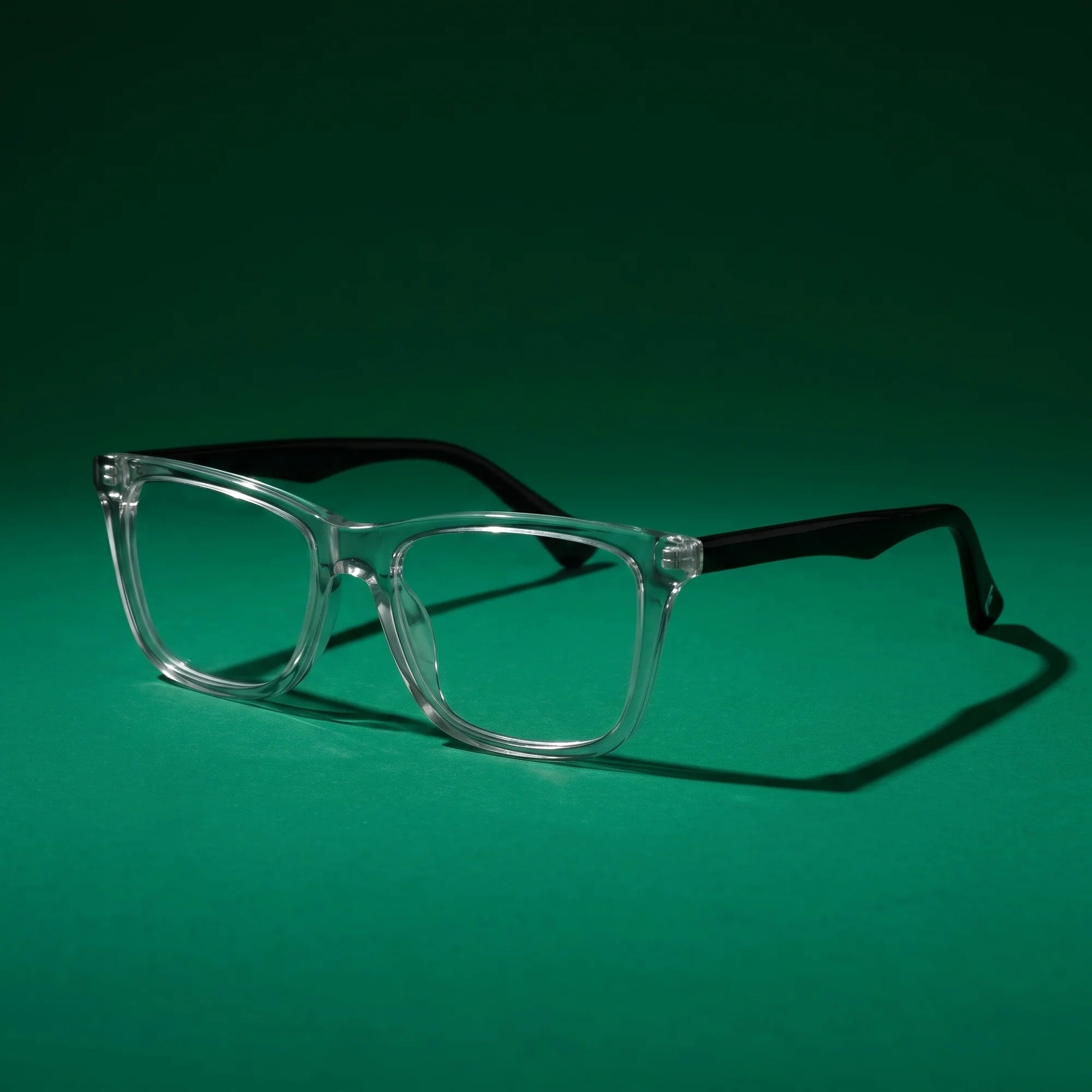 Fiore 5228 eyeglasses in transparent – still life on a seamless emerald studio backdrop