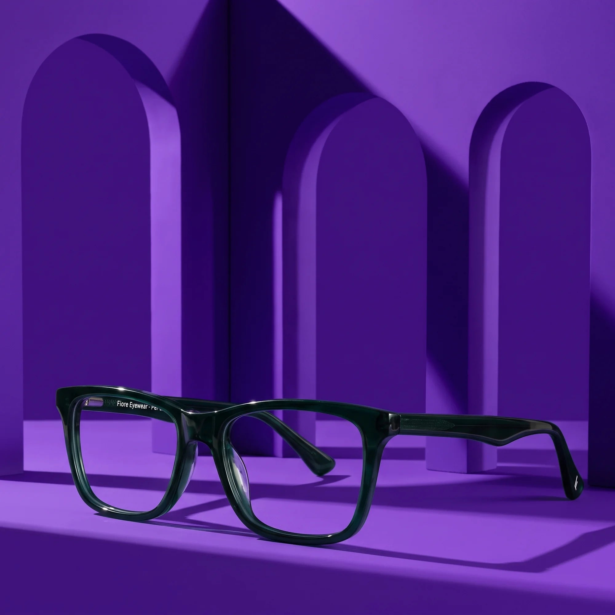Fiore 5228 eyeglasses in green – displayed on a violet podium among arches