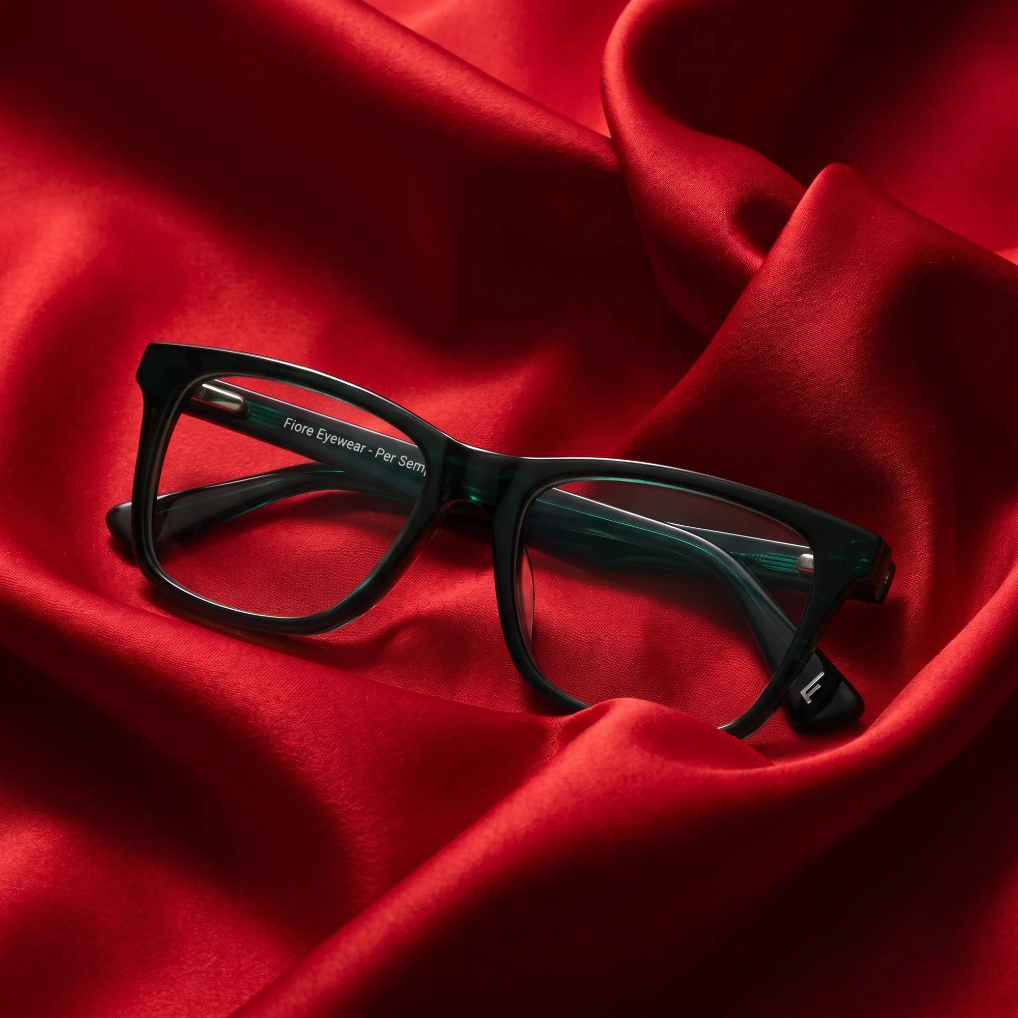 Fiore 5228 eyeglasses in green – nested in flowing vivid red silk