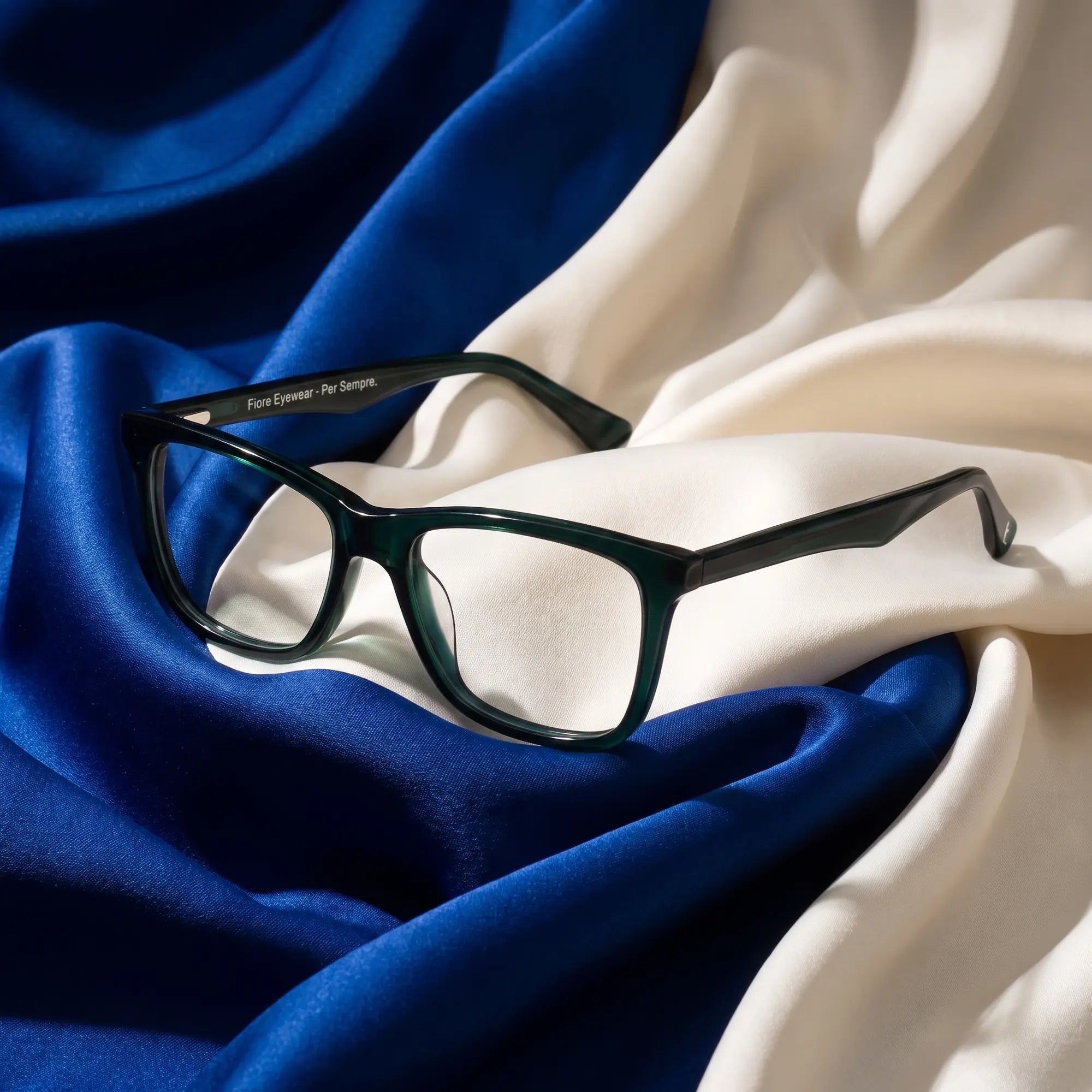 Fiore 5228 eyeglasses in green – resting on draped cobalt and ivory silk