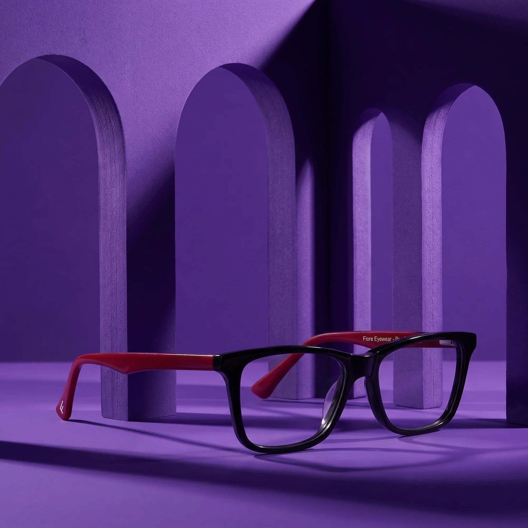 Fiore 5228 eyeglasses in black – staged on a sculptural violet architecture set