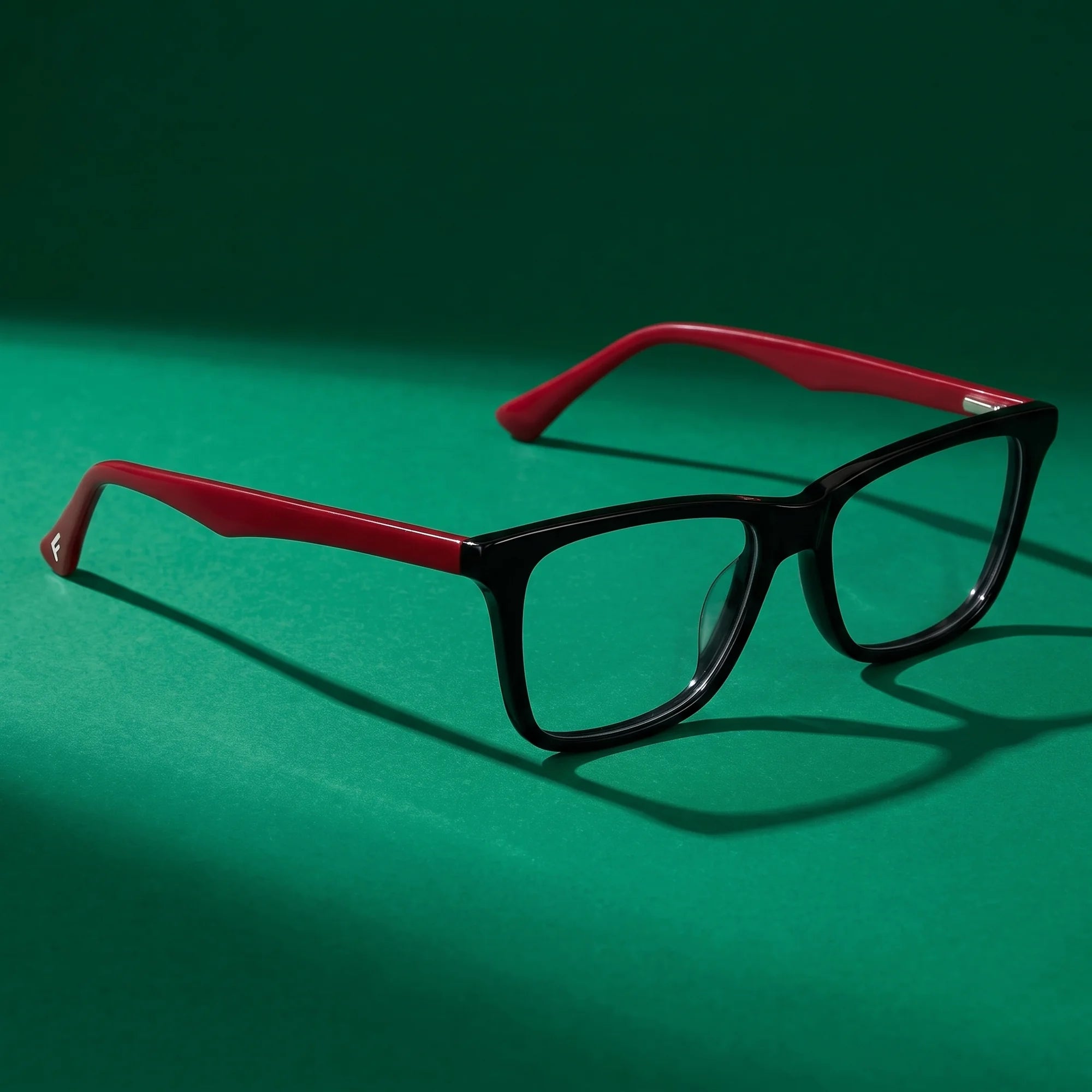 Fiore 5228 eyeglasses in black – editorial still life on a saturated emerald set