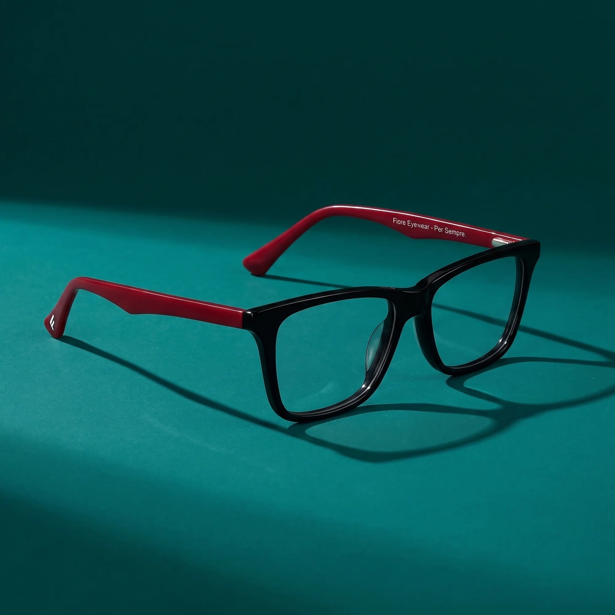Fiore 5228 eyeglasses in black – hero still life against a deep teal backdrop