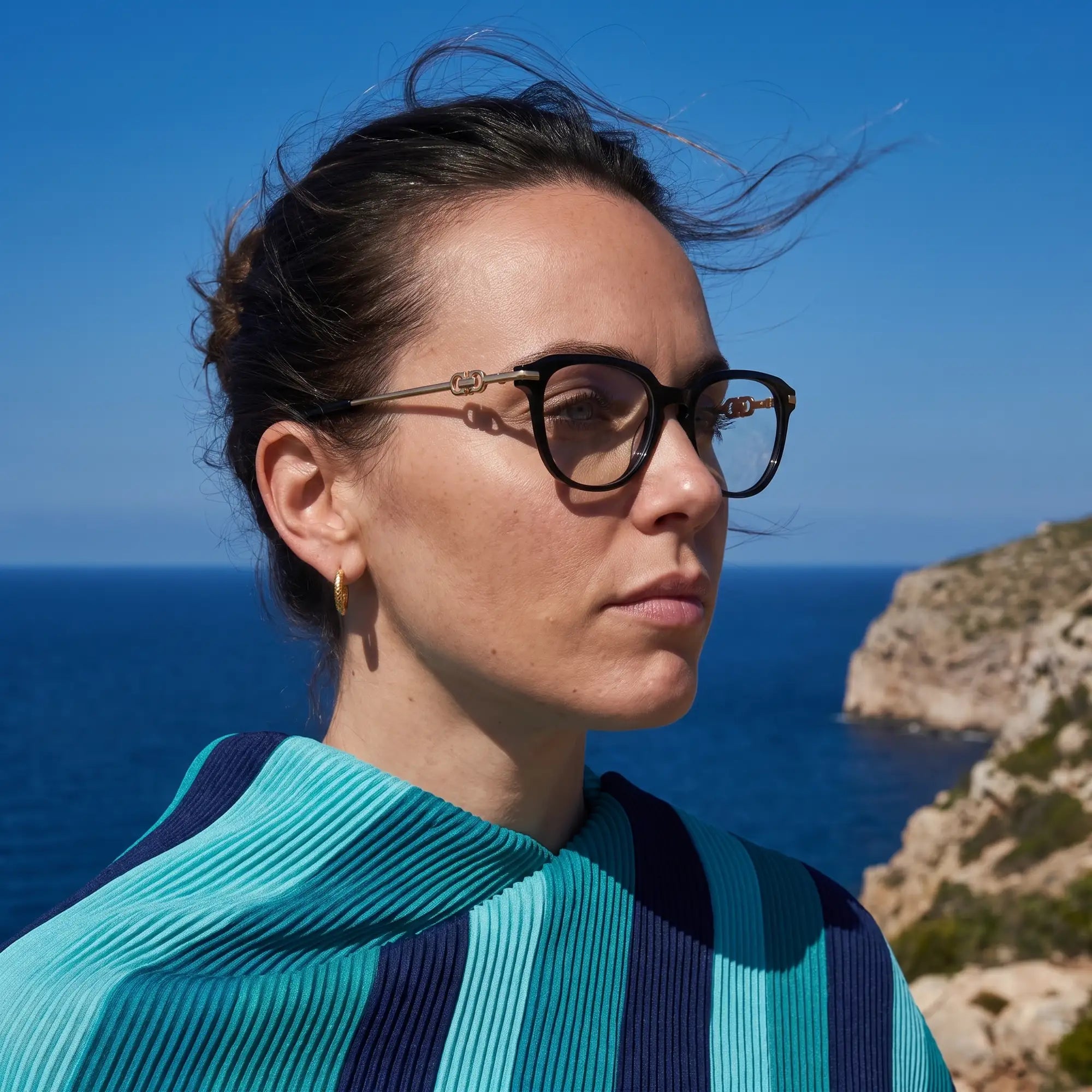 Fiore 5409 eyeglasses in black, worn by a model – campaign portrait, windswept portrait over the deep blue sea