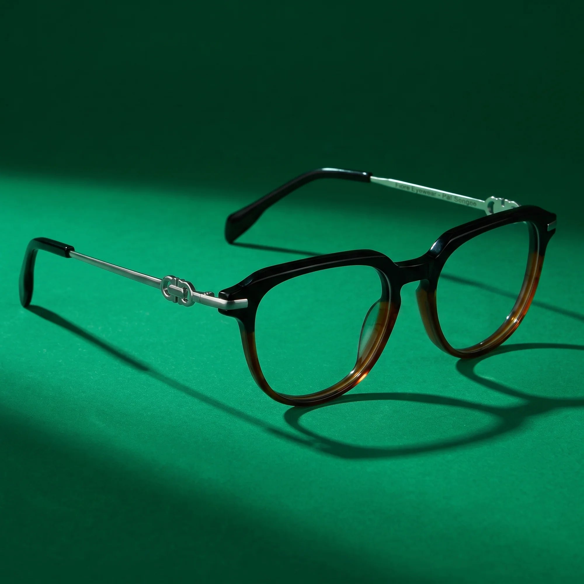 Fiore 5409 eyeglasses in black brown – editorial still life on a saturated emerald set