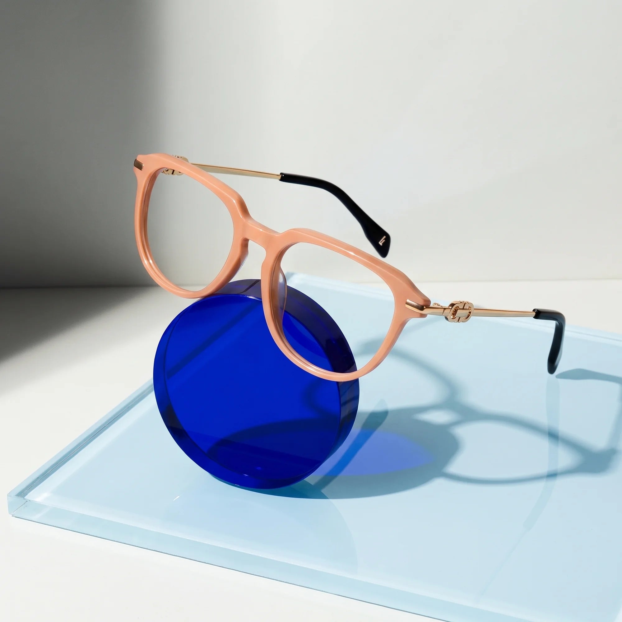 Fiore 5409 eyeglasses in milky white – on a cobalt acrylic disc in soft daylight