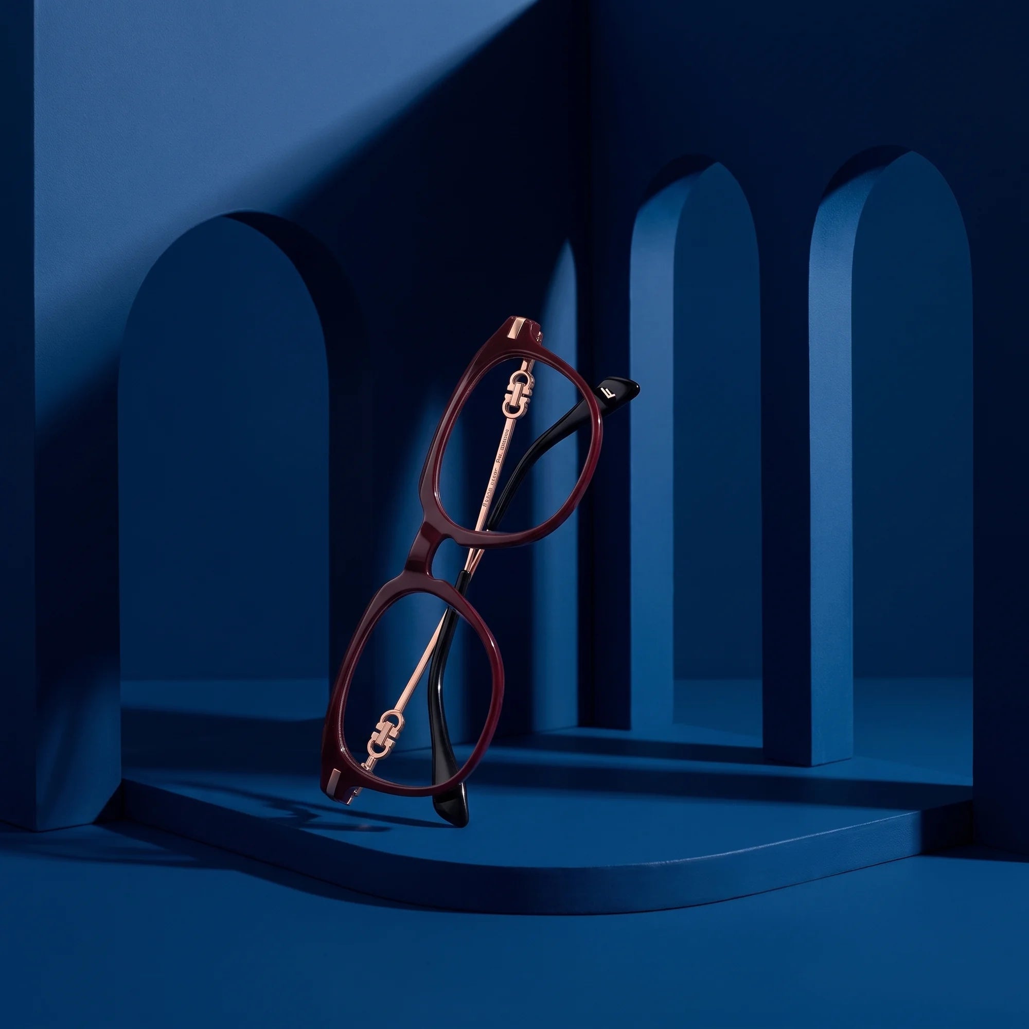Fiore 5409 eyeglasses in brown red – staged on a sculptural midnight blue architecture set