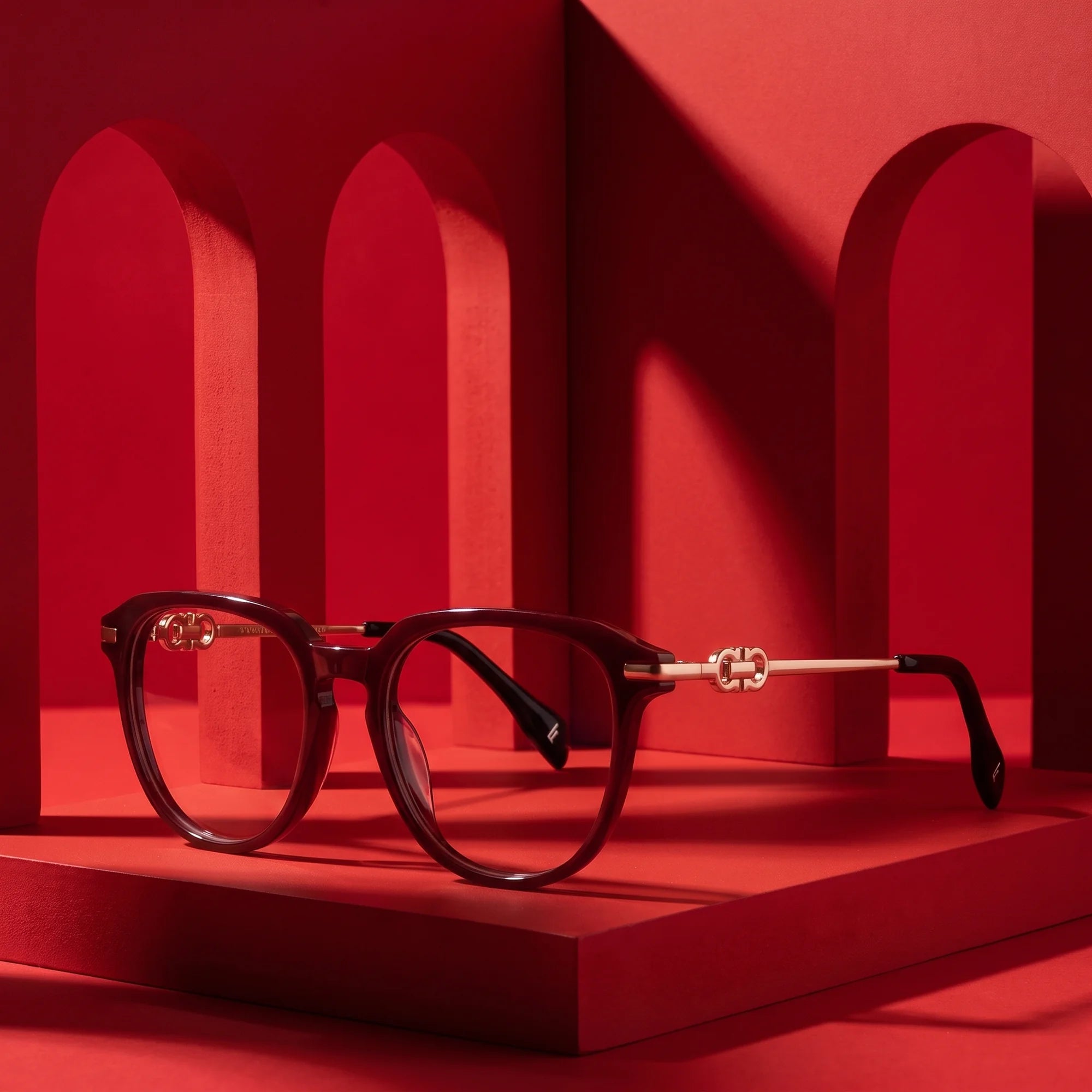 Fiore 5409 eyeglasses in brown red – displayed on a vivid red podium among arches