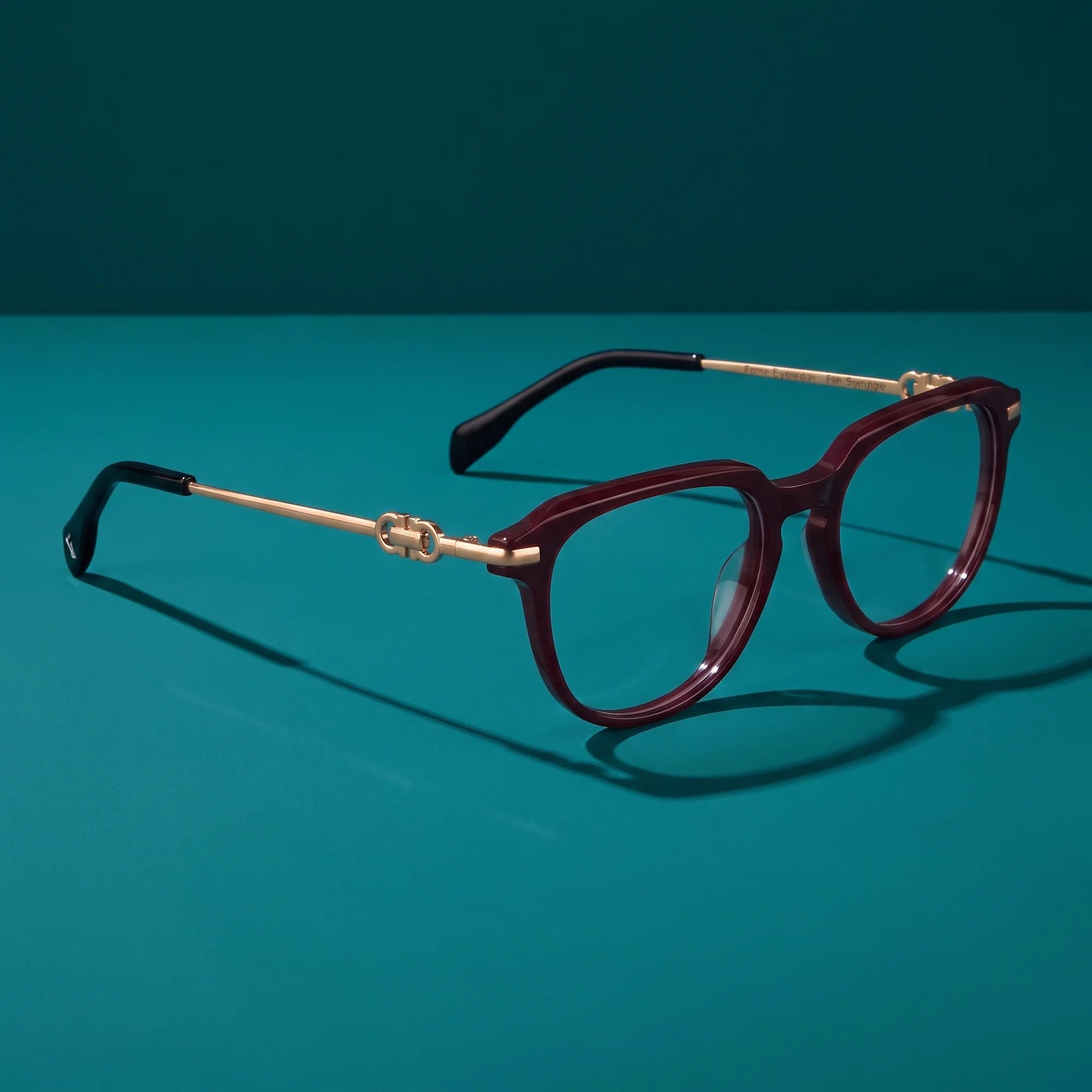 Fiore 5409 eyeglasses in brown red – hero still life against a deep teal backdrop