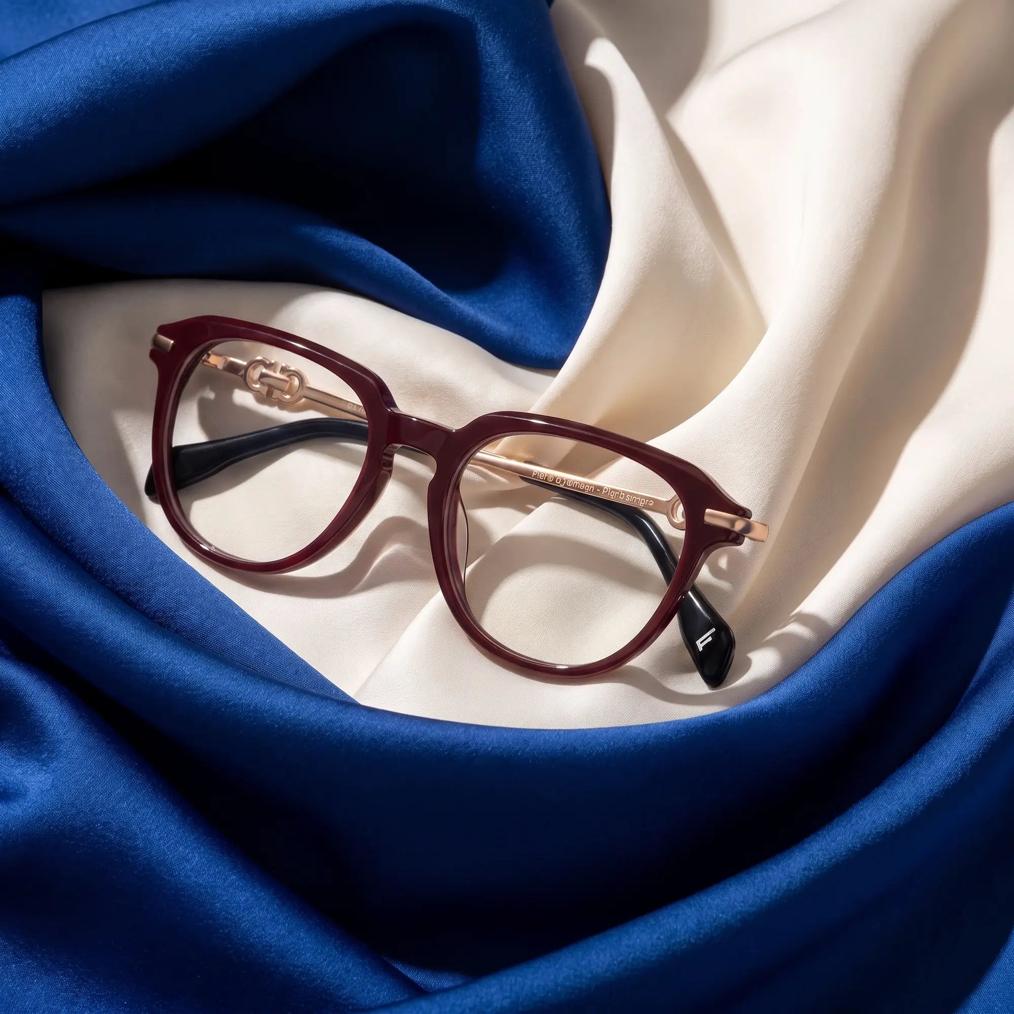 Fiore 5409 eyeglasses in brown red – resting on draped cobalt and ivory silk