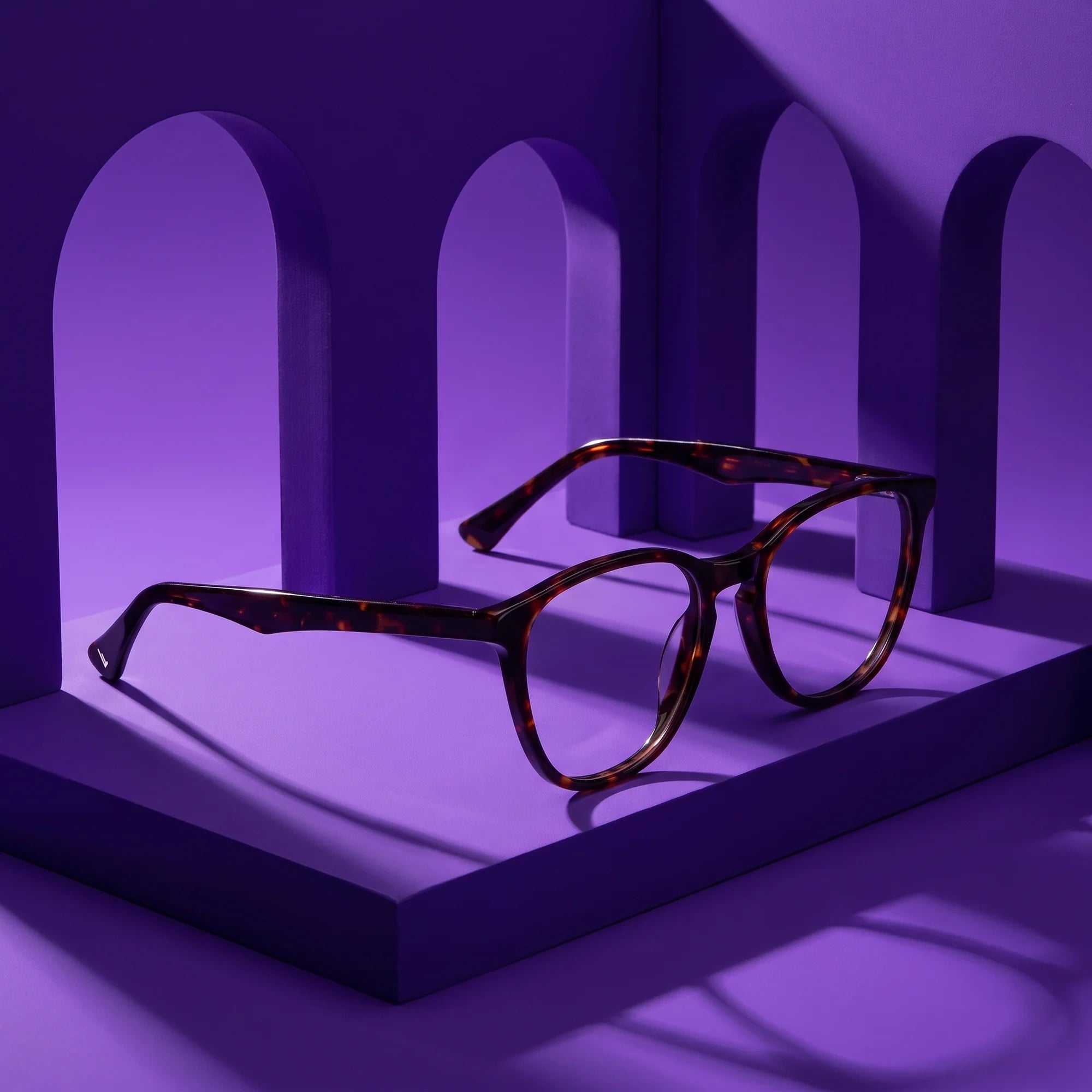 Fiore 7046 eyeglasses in tortoiseshell – displayed on a violet podium among arches
