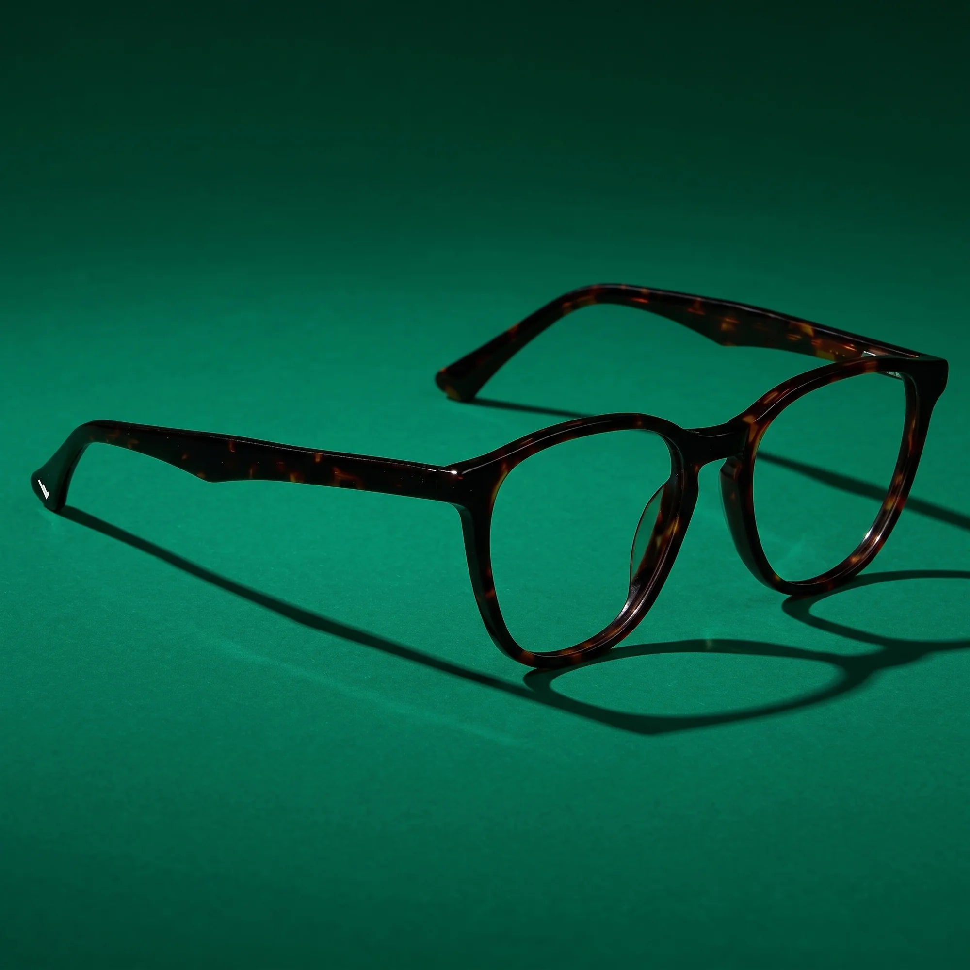 Fiore 7046 eyeglasses in tortoiseshell – still life on a seamless emerald studio backdrop