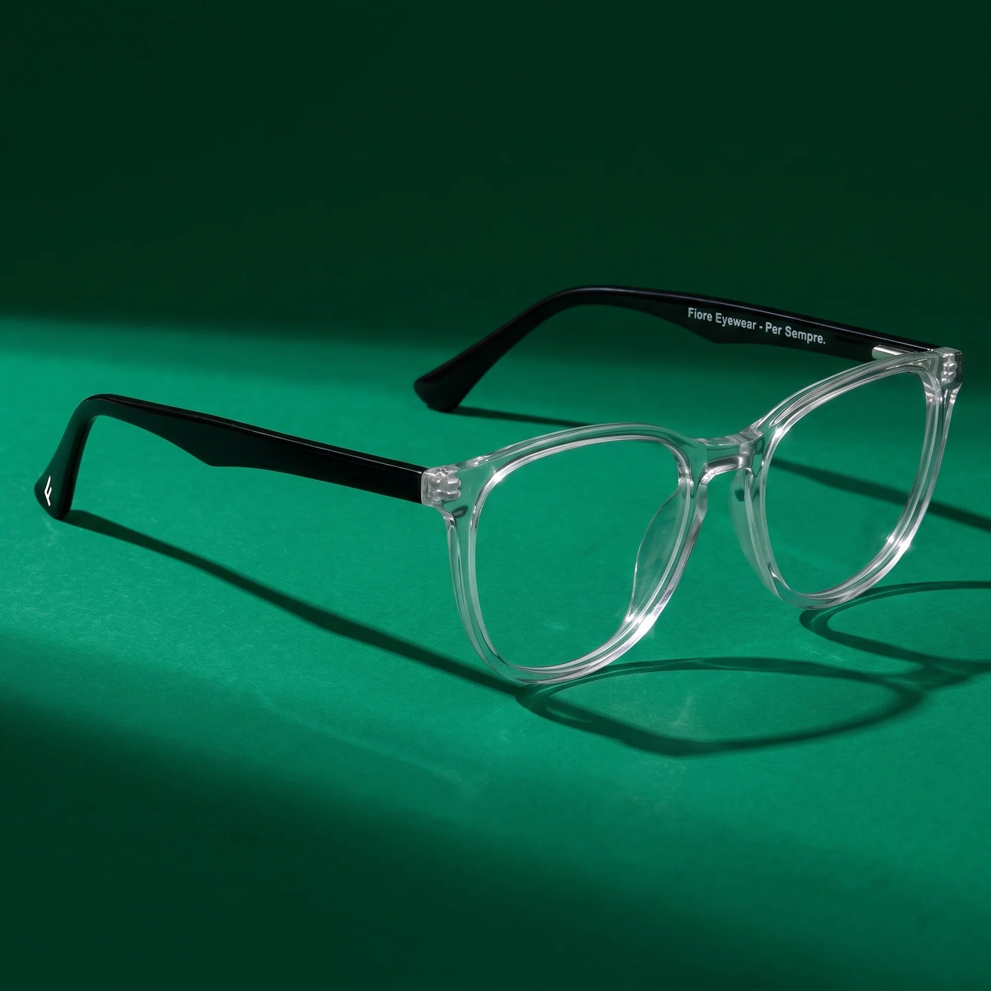 Fiore 7046 eyeglasses in transparent – still life on a seamless emerald studio backdrop