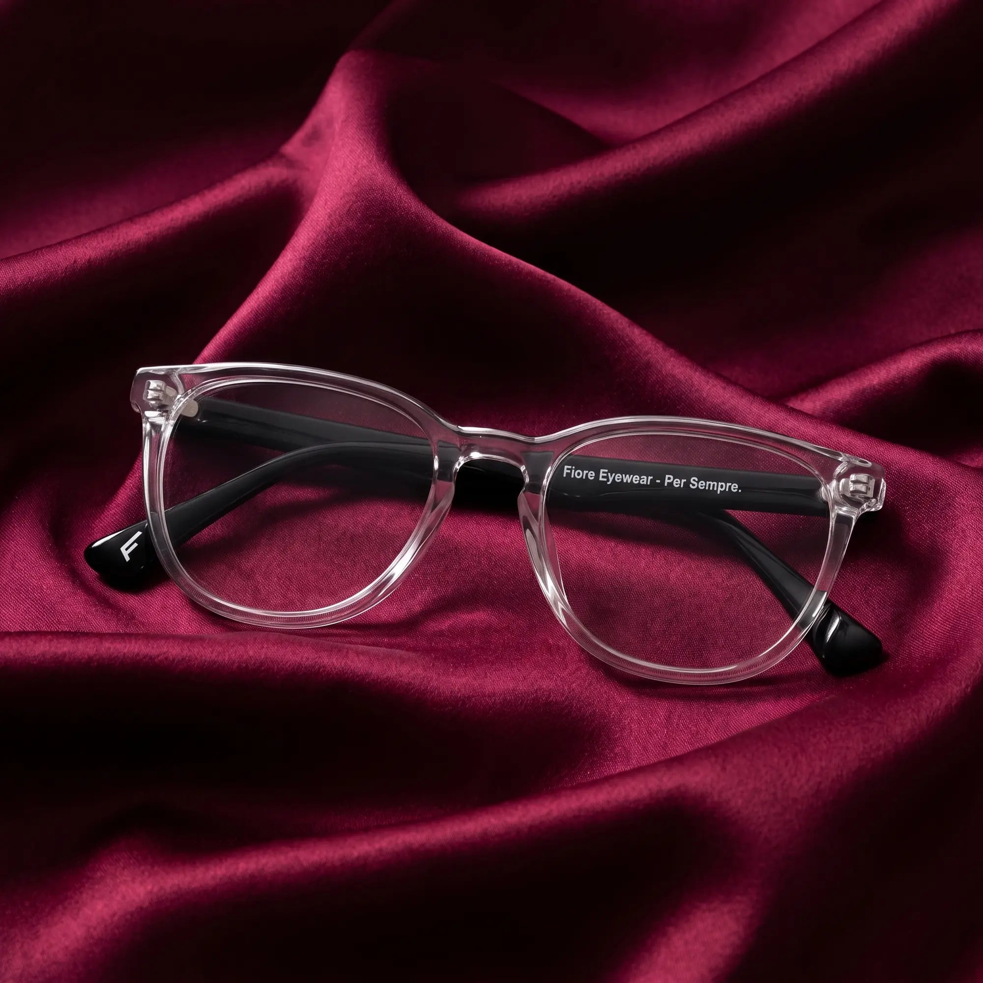 Fiore 7046 eyeglasses in transparent – nested in flowing burgundy silk